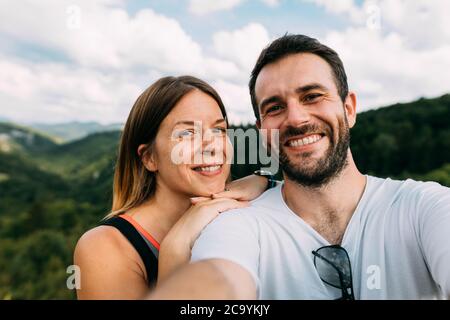 Junges Paar, das ein Selfie in den Bergen nimmt Stockfoto