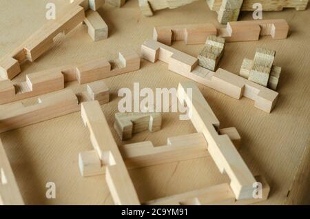 Details des Kinderholzkonstruktors zufällig auf dem Holztisch. Nahaufnahme eines sich entwickelnden Kinderspielzeugs. Selektiver Fokus. Speicherplatz kopieren. Stockfoto