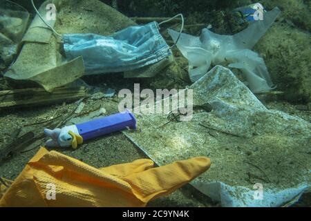 Becici, Budva Gemeinde, Montenegro, Europa. Juli 2020. BECICI UND BUDVA, BUDVA GEMEINDE, MONTENEGRO - 31. JULI 2020: Plastik und andere Müll verschmutzen in der Adria. Gebrauchte medizinische Gesichtsmasken nach COVID-19 am Strand entsorgt und ins Meer fällt, treibt unter Wasser zusammen mit Plastikmüll und am Boden niederlassen, nähert sich einer ökologischen Katastrophe. Weggeworfene gebrauchte medizinische Gesichtsmaske zusammen mit anderen Plastikmüll liegt auf dem Meeresboden. Kredit: Andrey Nekrasov/ZUMA Wire/Alamy Live Nachrichten Stockfoto