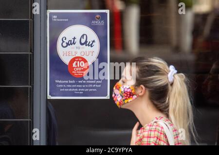 Die Leute passieren ein Schild mit der Werbung für das "Eat Out to Help Out"-Programm, in Covent Garden, London. Ab Montag können die Gäste Mahlzeiten zum halben Preis genießen, da die Regierung ihr August-Programm startet, das darauf abzielt, den Handel mit Restaurants und Pubs nach der Sperre zu fördern. Stockfoto