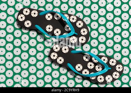 Massagematte für Akupunktur und Schwimmbadflipflops für die Wirbelsäule. Grüne und blaue Farbe. Massage zu Hause, Akupunktur-Konzept. Stockfoto