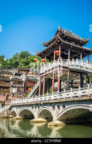 Feng Huang, China - August 2019 : Vertikale Ansicht der alten historischen gewölbten Xueqiao Schnee-Brücke am Ufer des Tuo-Flusses, die durch die ce fließt Stockfoto