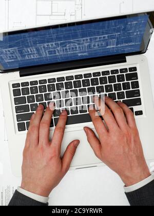 Mann, der sich die Entwürfe auf dem Laptop ansieht Stockfoto