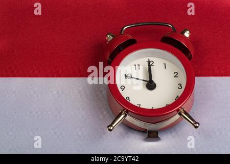 Polen Flagge und Vintage-Wecker auf Nahaufnahme. Zeit, Polnisch zu lernen. Stockfoto