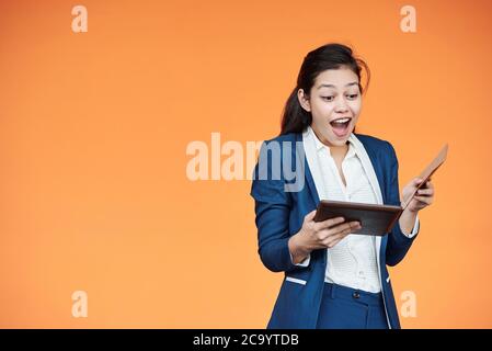 Aufgeregt junge Unternehmerin Überprüfung E-Mails auf Tablet-Computer mit guten Nachrichten Stockfoto