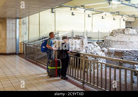 Athen - 9. Mai 2018: Touristen schauen sich antike Ruinen in der Monastirion (Monastiraki) U-Bahnstation im Stadtzentrum von Athen an. U-Bahn innen mit Stockfoto