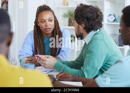 Porträt einer afroamerikanischen Frau, die während eines Geschäftstreffens im Büro mit Kollegen spricht Stockfoto