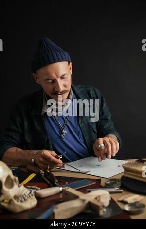 Lederwaren master Hände und handgefertigtem Leder Geldbörsen lag auf Tabelle mit crafting Tools. Workflow in der Werkstatt. Workflow in der Werkstatt, close-up Stockfoto