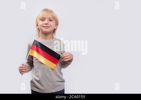 Blonde deutsche Junge mit Nationalflagge in den Händen. Patriotismus in Deutschland. Stockfoto