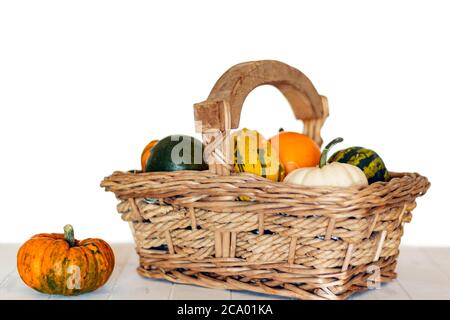 Kürbissortiment auf Korbkorb und Holztisch Stockfoto