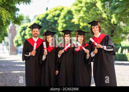 Gruppe von Studenten der Graduierung im Park suchen glücklich Stockfoto