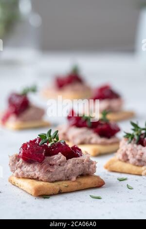 Cracker mit Pastete und Preiselbeersoße Stockfoto