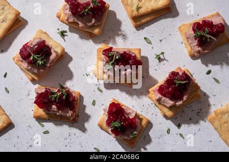 Cracker mit Pastete und Preiselbeersoße Stockfoto