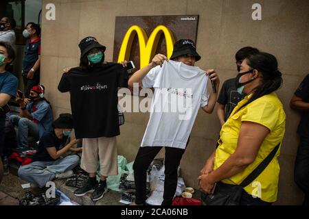 Bangkok, Thailand. August 2020. Prodemokratische Demonstranten verkaufen T-Shirts auf dem Bürgersteig gegenüber dem Democracy Monument während eines Harry Potter-Protestes in Bangkok, Thailand, Montag, 3. August 2020. Der prodemokratische Protest trug den Titel "Gießen des Patronus-Charms zum Schutz der Demokratie", Teil einer Reihe von Protesten in den letzten Wochen. Die Proteste sind seit Februar wegen des COVID-19 Ausbruchs eingestellt, aber Thailand hat in mehr als zwei Monaten keine neuen lokalen Übertragungen mehr registriert und die pro-demokratischen Zusammenkünfte beginnen wieder an Dynamik zu gewinnen. (Bild: © Andre Malerba/ZUM Stockfoto