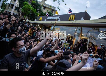 Bangkok, Thailand. August 2020. Prodemokratische Demonstranten halten auf dem Bürgersteig gegenüber dem Democracy Monument während eines Harry Potter-Protestes in Bangkok, Thailand, Montag, 3. August 2020, Stäbchen auf. Der prodemokratische Protest trug den Titel "Gießen des Patronus-Charms zum Schutz der Demokratie", Teil einer Reihe von Protesten in den letzten Wochen. Die Proteste sind seit Februar wegen des COVID-19 Ausbruchs eingestellt, aber Thailand hat in mehr als zwei Monaten keine neuen lokalen Übertragungen mehr registriert und die pro-demokratischen Zusammenkünfte beginnen wieder an Dynamik zu gewinnen. (Bild: © Und Stockfoto