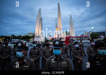 Bangkok, Thailand. August 2020. Polizeibeamte stehen Wache gegenüber dem Democracy Monument während eines Harry Potter Protestes in Bangkok, Thailand, Montag, 3. August 2020. Der prodemokratische Protest trug den Titel "Gießen des Patronus-Charms zum Schutz der Demokratie", Teil einer Reihe von Protesten in den letzten Wochen. Die Proteste sind seit Februar wegen des COVID-19 Ausbruchs eingestellt, aber Thailand hat in mehr als zwei Monaten keine neuen lokalen Übertragungen mehr registriert und die pro-demokratischen Zusammenkünfte beginnen wieder an Dynamik zu gewinnen. Quelle: Andre Malerba/ZUMA Wire/Alamy Live News Stockfoto