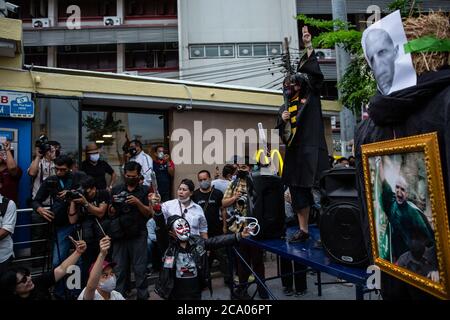 Bangkok, Thailand. August 2020. Prodemokratische Demonstranten, die als Zauberer verkleidet sind, Oder tragen Masken und halten Essstäbchen "Stäbe," sitzen neben einem Stroh-Bildnis mit VoldemortÃs Gesicht - gemeint, um den aktuellen Premierminister Prayut Chan-O-Cha symbolisieren - auf dem Bürgersteig gegenüber dem Demokratie-Denkmal während eines Harry Potter-Motto Protest in Bangkok, Thailand, Montag, 3. August 2020. Der prodemokratische Protest trug den Titel "Gießen des Patronus-Charms zum Schutz der Demokratie", Teil einer Reihe von Protesten in den letzten Wochen. Die Proteste sind seit Februar wegen des COVID-19 Ausbruchs eingestellt, BU Stockfoto