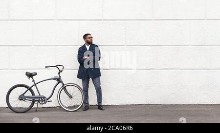 Schöner afro Geschäftsmann posiert mit seinem Fahrrad Stockfoto