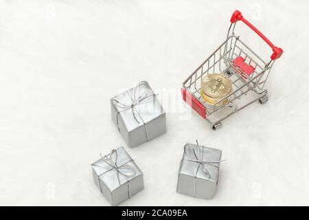Bitcoin Münzen im Warenkorb und Geschenke. Weißer Hintergrund Stockfoto