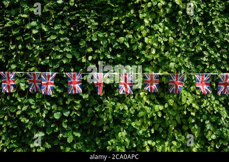 V E Tag 2020 Union Jack Verzierung einer Gartenhecke eines Hauses auf einer ländlichen Wohnstraße während Coronavirus Sperre Surrey England UK Stockfoto