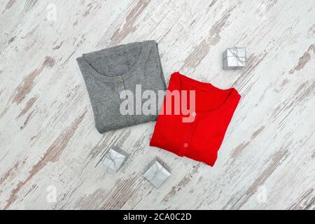 Zwei Pullover und silberne Schachteln auf einem Holzhintergrund. Modisches Konzept Stockfoto
