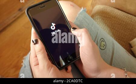 Nahaufnahme eines Smartphones in der Hand eines Mädchens, Öffnen der TikTok App. Illustrative Editorial aufgenommen in Vista, CA / USA am 2. August 2020. Stockfoto