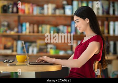 Remote-Work-Konzept. Asiatische Frau Mit Laptop Während Kaffee Trinken Im Café Stockfoto