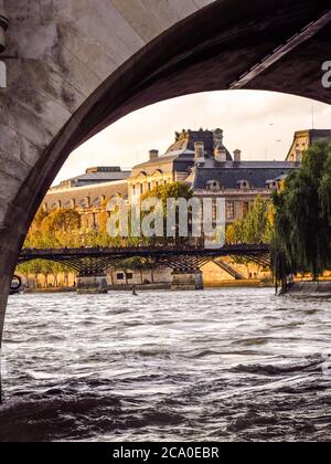 Blick auf die Pont des Arts durch einen der Bögen der Pont Neuf, fotografiert am späten Nachmittag, auf dem Fluss sein in Paris, Frankreich Stockfoto