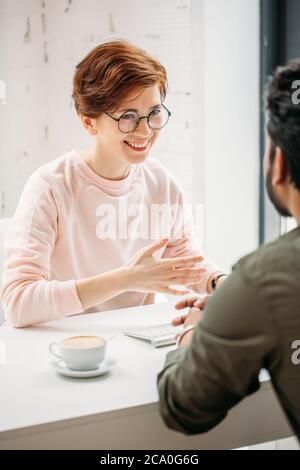 Portrait der Investmentberaterin Geschäftsfrau sitzen am Computer und Beratung mit jungen professionellen Mann oder Client Stockfoto