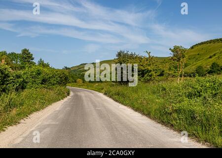 Eine Straße durch die Landschaft von Sussex an einem sonnigen Sommertag Stockfoto