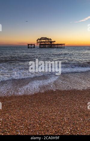 Der Pebble Beach und der West Pier bei Sonnenuntergang, in Brighton Stockfoto