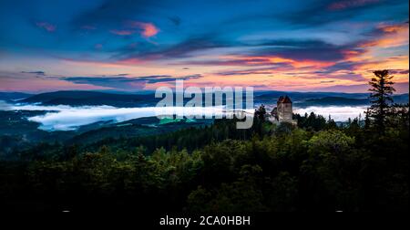 Sonnenuntergang in Kasperk Schloss, Sumava, Tschechische Republik. Kalter Tag im Sumava Nationalpark, Hügel und Dörfer im Nebel, nebliger Blick auf die tschechische Landschaft, sogar Stockfoto