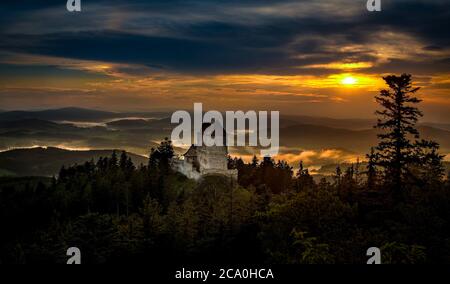 Sonnenuntergang in Kasperk Schloss, Sumava, Tschechische Republik. Kalter Tag im Sumava Nationalpark, Hügel und Dörfer im Nebel, nebliger Blick auf die tschechische Landschaft, sogar Stockfoto