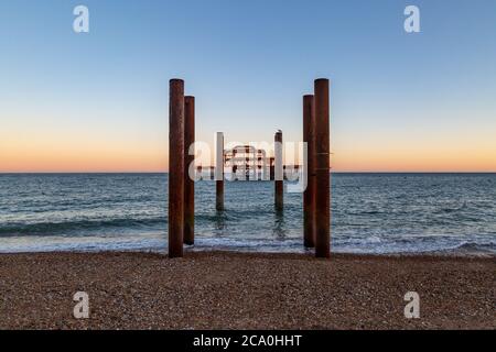 Die Ruinen des West Pier in Brighton mit einem Sonnenuntergang Himmel hinter Stockfoto