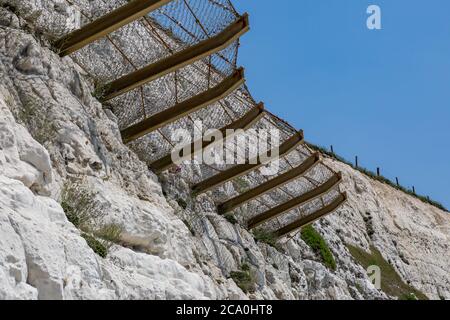 Schützendes Netz auf einer Kreidefelsen, um fallende Felsen zu fangen Stockfoto