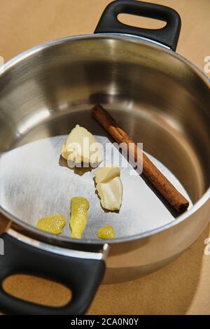 Stahltopf vorbereitet mit Zimt, Zitrone und Butter zum Eingießen von Milch und Stockfoto