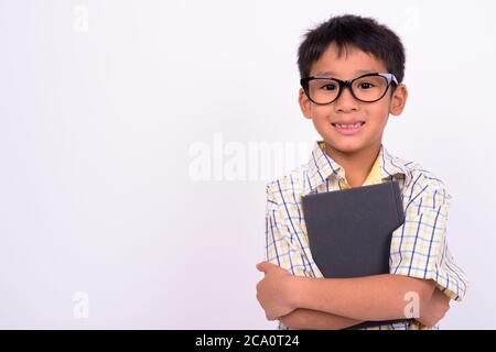 Portrait von niedlichen asiatischen Jungen tragen Brillen als Student mit Buch Stockfoto