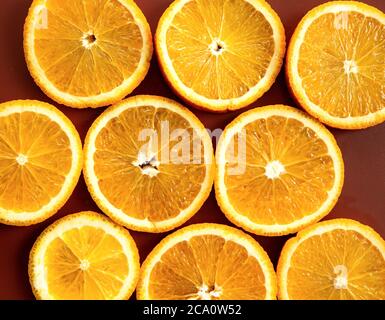 Farbenprächtiges Fruchtmuster aus frischen Orangenscheiben und mit Rosmarinblättern auf gewachsenem Hintergrund. Stockfoto
