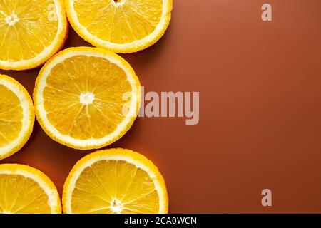 Farbenprächtiges Fruchtmuster aus frischen Orangenscheiben und mit Rosmarinblättern auf gewachsenem Hintergrund. Stockfoto