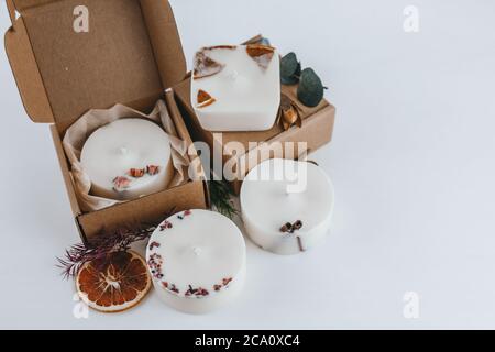 Handgemachte Duftkerzen aus Sojawachs. Aromatherapie, Dekoration, Duftkerzen mit getrockneten Blumen und Früchten. Öko-Paket, Karton. Stockfoto