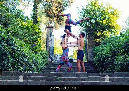 Schöner Mann und zwei Frauen üben acroyoga Stockfoto