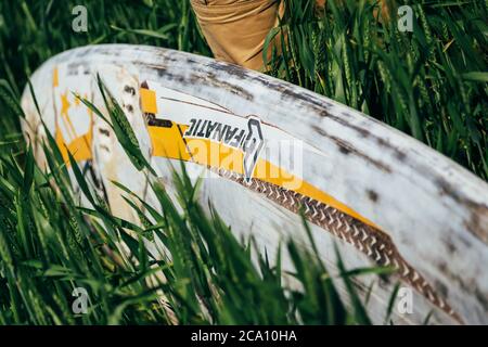 ODESSA, UKRAINE - MAI, 20 2015: Nahaufnahme eines alten Surfbretts im hohen Gras Stockfoto