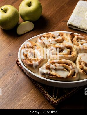 Vegetarische Zimtrollen mit Apfel auf einem Holzbrett. Stockfoto