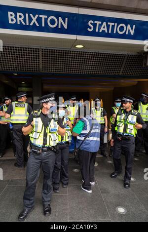 Polizeibeamte schließen Brixton Station während des African Emancipation Day Reparations March, London, 1. August 2020 Stockfoto