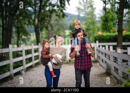 Porträt der Familie mit kleinen Kindern zu Fuß auf dem Bauernhof. Stockfoto