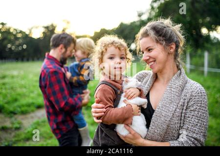 Porträt der Familie mit kleinen Kindern auf dem Bauernhof stehen. Stockfoto