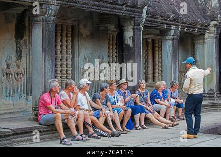 Westliche ältere Touristen mit Führer, der den Tempelkomplex Angkor Wat aus dem 12. Jahrhundert besucht, der dem gott Vishnu, Siem Reap, Kambodscha, Asien gewidmet ist Stockfoto