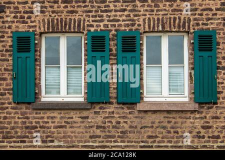 Verkauft weiß gerahmte Fenster auf mittelmeer-Haus aus Ziegelwänden mit grünen Fensterläden Stockfoto