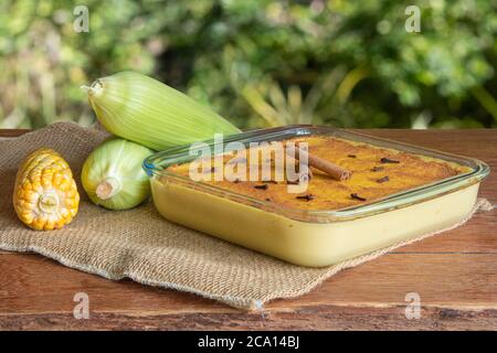 Canjica Curau. Typische brasilianische Junina Party Süßigkeiten. Maiskolben. Verschwommener grüner Hintergrund. Brasilianisches Dessert Stockfoto