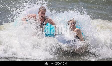 Malaga, Spanien. August 2020. An den Stränden von Pedregalejo in Malaga haben junge Leute Spaß in den Wellen des Meeres während der afrikanischen Hitzewelle im Wasser des Strandes. Kredit: Lorenzo Carnero/ZUMA Wire/Alamy Live Nachrichten Stockfoto